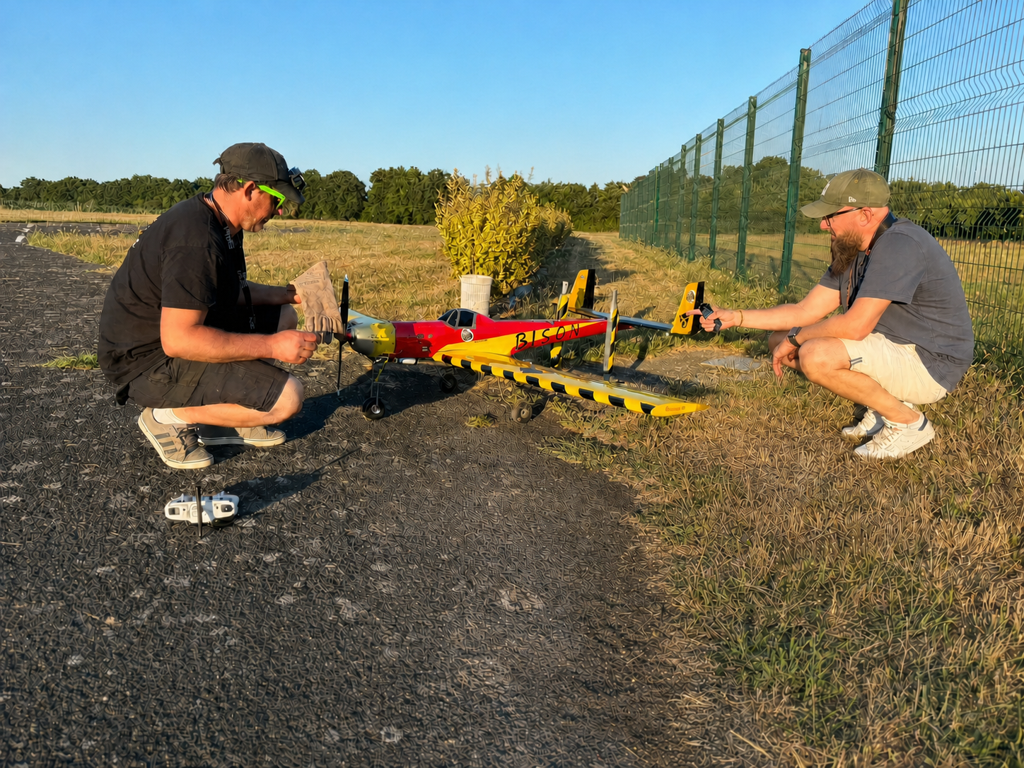 Laurent et Patrice44 accroupis près du Bison sur le bord de la piste, pendant les derniers contrôles de l’avion.