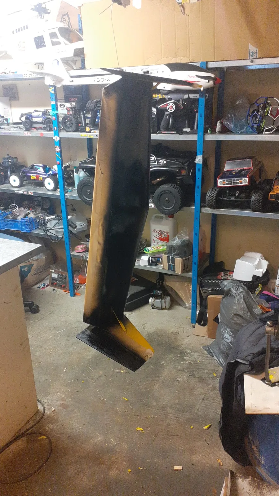Pièce noire de l’avion suspendue dans l’atelier avant reprise.