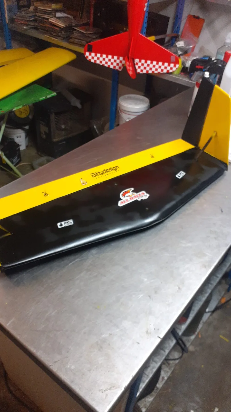 Empennage horizontal jaune et noir posé sur une table d’atelier.