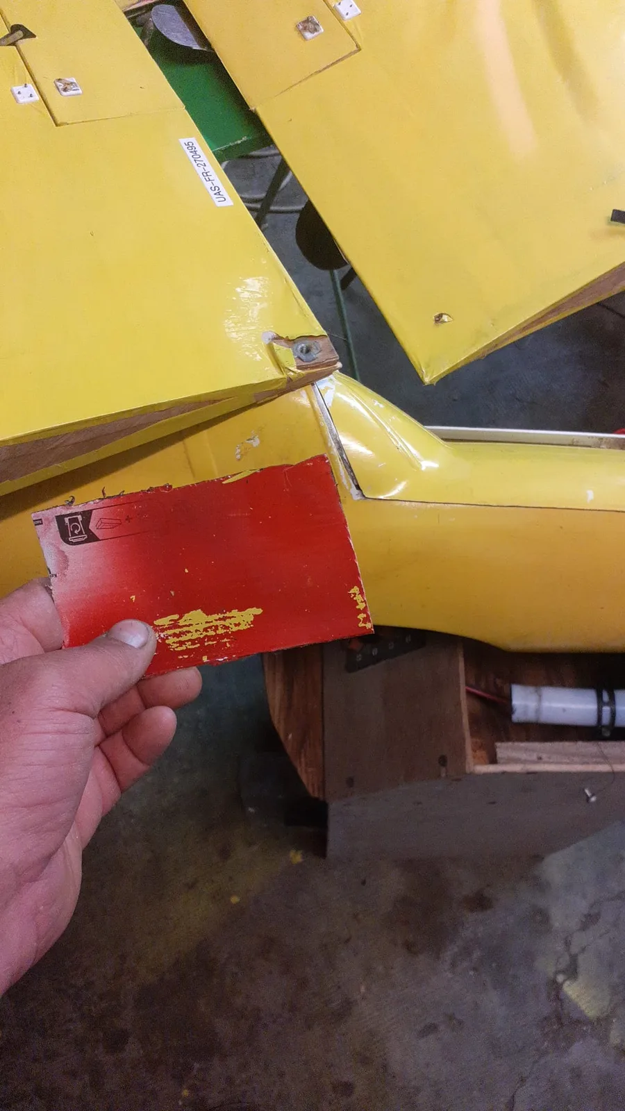 Zone d’empennage du Bison avec une pièce rouge tenue à la main pour montrer la reprise à effectuer.