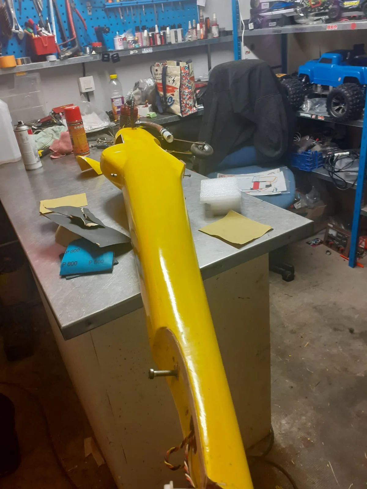 Fuselage jaune du Bison avec abrasifs et pièces de finition sur la table.