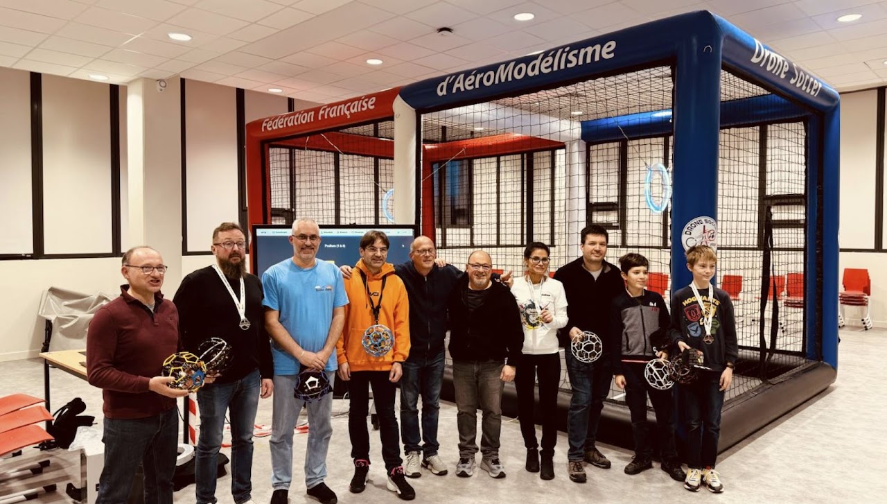 Groupe de pilotes devant une cage Drone Soccer FFAM